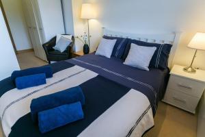 1 dormitorio con 1 cama grande con almohadas azules en Bwthyn Bach en Llanrhyddlad