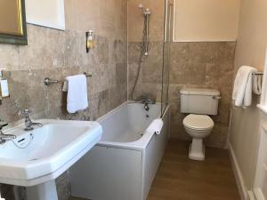 a bathroom with a tub and a toilet and a sink at Victoria inn in Durham