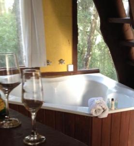 bañera con copa de vino y 2 copas de vino en Chalés Sol e Lua, en Campos do Jordão