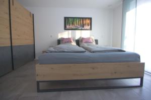 a bedroom with a large bed with a wooden frame at Ferienwohnung Hegaublüte in Engen