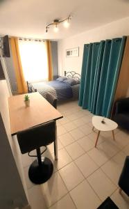 - un salon avec une table et un lit dans l'établissement Charmant studio en plein centre avec parking, à Saint-Omer