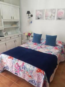 a bedroom with a bed with blue pillows on it at Marine Studio on the Beach in Icod de los Vinos