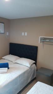a bedroom with a bed with a black headboard at Pousada São Pedro in São Pedro da Aldeia