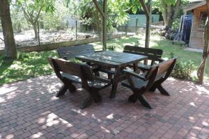a picnic table with three benches sitting around it at Vakantiewoning Zoetebeek in Oudenaarde