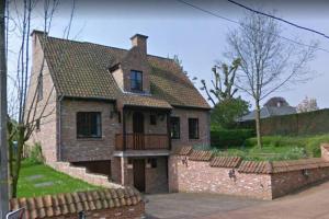 a brick house with a balcony and a brick wall at Vakantiewoning Zoetebeek in Oudenaarde