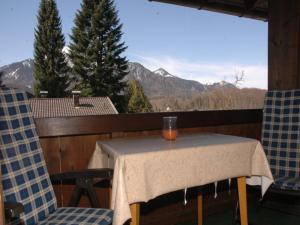 a table and chairs on a balcony with a view at Haus Auracher in Unterwössen