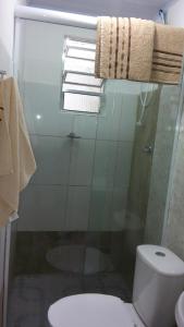 uma casa de banho com um WC e uma cabina de duche em vidro. em Apto sereno próximo a Expo São Paulo! em São Paulo