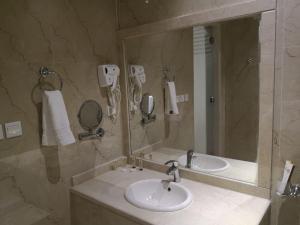 a bathroom with two sinks and a large mirror at Makarem Hotel Apartment - مكارم للشقق الفندقية in Riyadh +32 photos