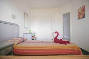 ein Schlafzimmer mit einem Bett mit einem roten Schwan darauf in der Unterkunft Primera linea playa, vista espectacular in El Médano + 13 Fotos