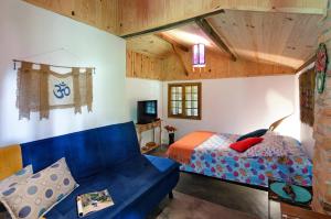 a bedroom with a blue couch and a bed at Karunâ in Visconde De Maua