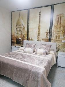 1 dormitorio con 1 cama grande y una foto de la torre Eiffel en Hostal Restaurante Casa Isabel, en Gamonal