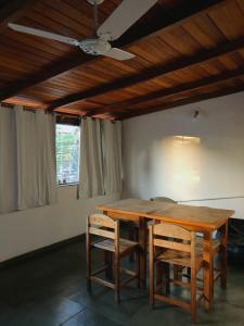 a dining room table with chairs and a ceiling fan at Anexo Aldeia Búzios in Búzios