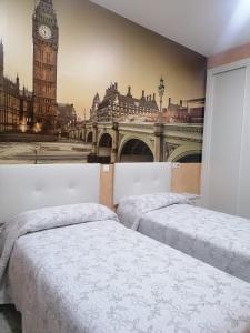 2 bedden in een kamer met uitzicht op Big Ben bij Hostal Restaurante Casa Isabel in Gamonal