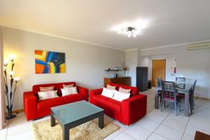 - un salon avec un canapé rouge et une table dans l'établissement Terraços de Vilamoura 55- Clever Details, à Vilamoura
