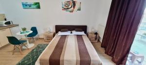 sypialnia z dużym łóżkiem, stołem i krzesłami w obiekcie Studio Escape Mamaia next by LOFT w Mamai
