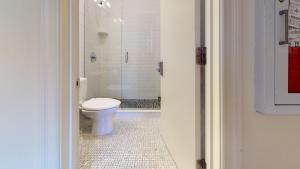 a white bathroom with a toilet and a shower at Stylish Downtown Studio in the SouthEnd, C.Ave #43 in Boston +8 photos