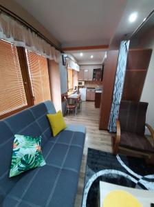 APARTAMENT CIEŃ GIEWONTU في زاكوباني: غرفة معيشة مع أريكة زرقاء وطاولة