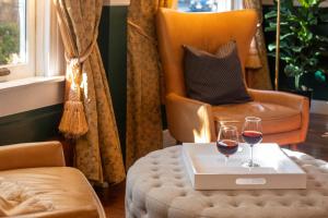 a room with a chair and two glasses of wine on a table at Washington Square Inn in San Francisco