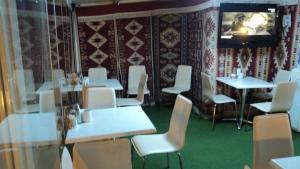 a restaurant with white tables and chairs and a television at Bade Otel in Istanbul