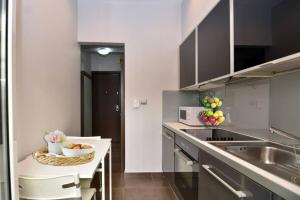 a kitchen with a bowl of fruit on a counter at Modern apartment in the heart of the city in Larisa