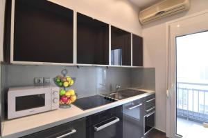 a kitchen with a sink and a microwave at Modern apartment in the heart of the city in Larisa