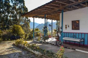 a bench on a porch with a view of a mountain at Hostal rural la montaña alquiyapura in Salento