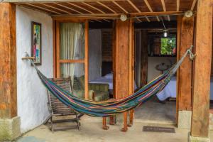 a hammock on a porch of a house at Hostal rural la montaña alquiyapura in Salento