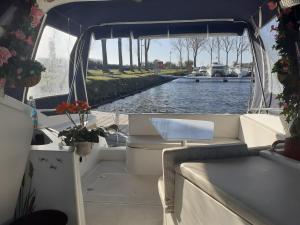 - un bateau avec un canapé et une table sur une rivière dans l'établissement Beau bateau Lilou 14, à Ouistreham