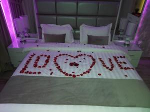 Una cama con un corazón hecho de rosas rojas en Makarem Hotel Apartment, en Riad