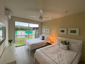 a bedroom with two beds and a couch and a window at Villa Marina Hotel in Playa Venao +217 photos