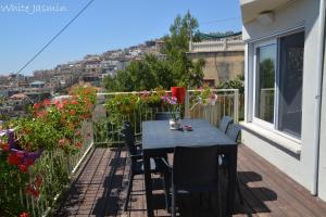 een patio met een tafel en stoelen op een balkon bij Jasmin Suites in Majdal Shams