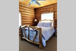 a bedroom with a bed in a log cabin at Red Rock Ranch Log Cabin: Large, Fully Furnished in Escalante