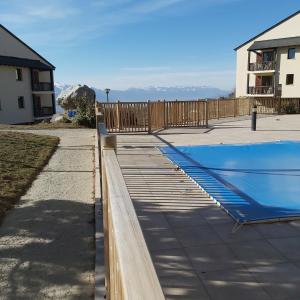 a swimming pool with a wooden deck next to a house at Résidence mille soleils in Font-Romeu