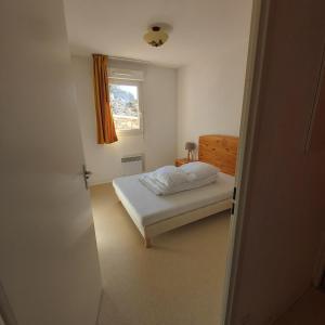 a small bedroom with a bed and a window at Résidence mille soleils in Font-Romeu
