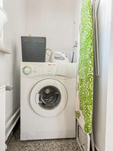 Una lavadora y secadora en una cocina con cortina en House Marin - whole house en Maribor