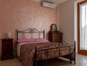 - une chambre avec un lit doté d'oreillers roses et d'un miroir dans l'établissement Casa in Chiana, à Torrita di Siena