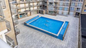 une vue aérienne d'une piscine dans une ville dans l'établissement Zonnig en gezellig appartement met zijdelings zeezicht en zwembad in Koksijde, à Coxyde