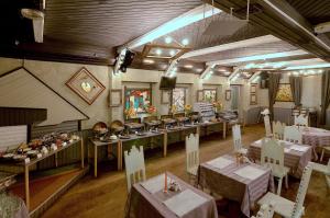 un restaurante con mesas y sillas en una habitación en Akvareli Resort, en Vereya