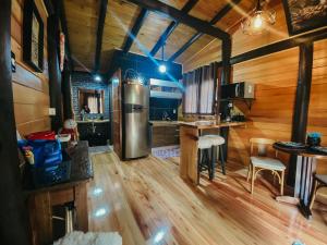 a kitchen with a stainless steel refrigerator and wooden walls at Sentiero Cabanas Boutique in Urubici
