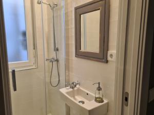 a bathroom with a sink and a shower with a mirror at 1930. DIECINUEVE TREINTA in Gijón