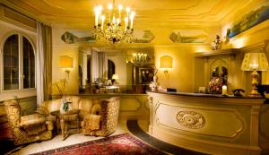- un salon avec deux chaises et un lustre dans l'établissement Park Hotel Ville Montefiori, à Gardone Riviera