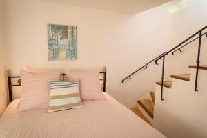 Schlafzimmer mit einem Bett mit gestreiftem Kissen in der Unterkunft The Little House in Bormes-les-Mimosas