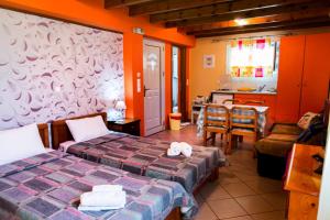 a room with two beds and a table and a kitchen at Alessandro in Sidari