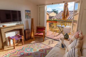ein Wohnzimmer mit einem Kamin und einem TV in der Unterkunft The Little House in Bormes-les-Mimosas