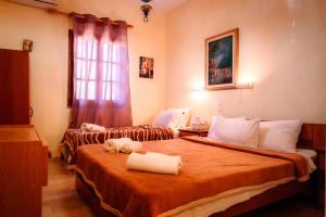 a hotel room with two beds with towels on them at Alessandro in Sidari