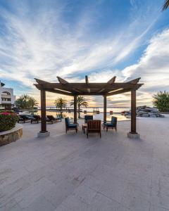 a wooden pavilion with chairs and tables on the beach at Playa de La Paz in La Paz