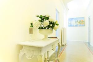 a vase with flowers on a table in a room at Lungomare Rooms & Charme in La Spezia