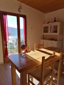 a wooden table and chairs in a kitchen with a window at Casetta delle olive in Tremosine Sul Garda