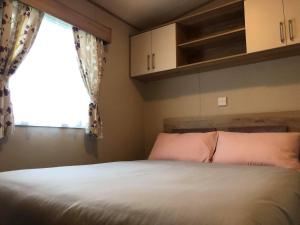 1 dormitorio con 1 cama grande y ventana en Laurel Superior Holiday Home en Mablethorpe