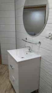 a bathroom with a white sink and a mirror at Apartamenty U Iwony Centrum miasta blisko Parku Zdrojowego in Kudowa-Zdrój
